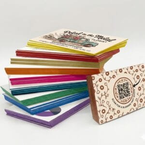 A collage showing a large stack of premium business cards with a variety of colorful painted edges, fanned out to display the diverse range of available shades.